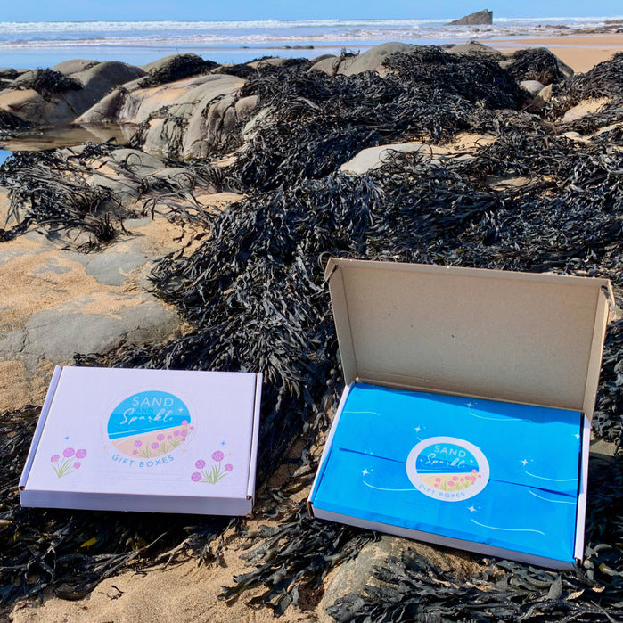 Letterbox gift sets from Sand and Sparkle pictured on the beach